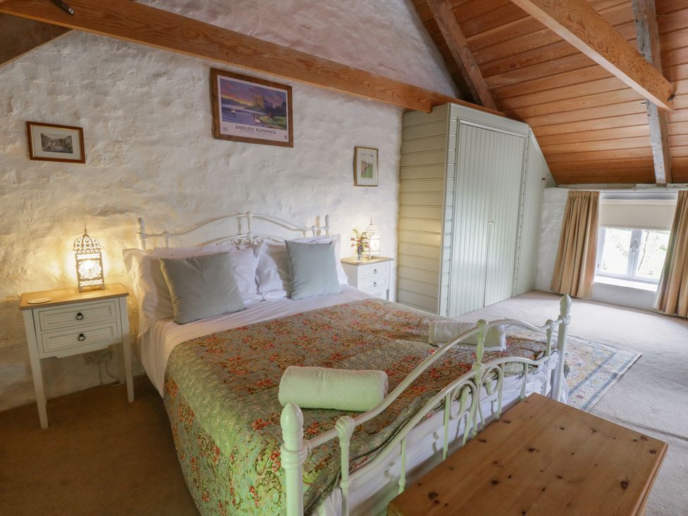 A bedroom with a bed and nightstand at Sycamore Vestry in Pontfaen near Fishguard