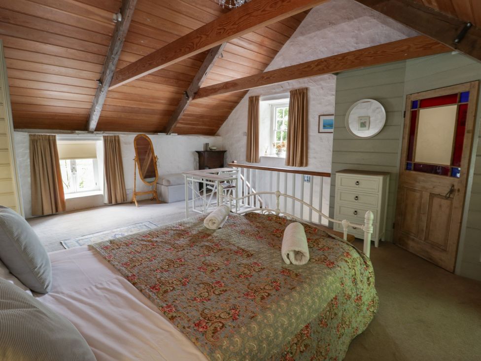 A bedroom with a bed and chair at Sycamore Vestry Pontfaen near Fishguard