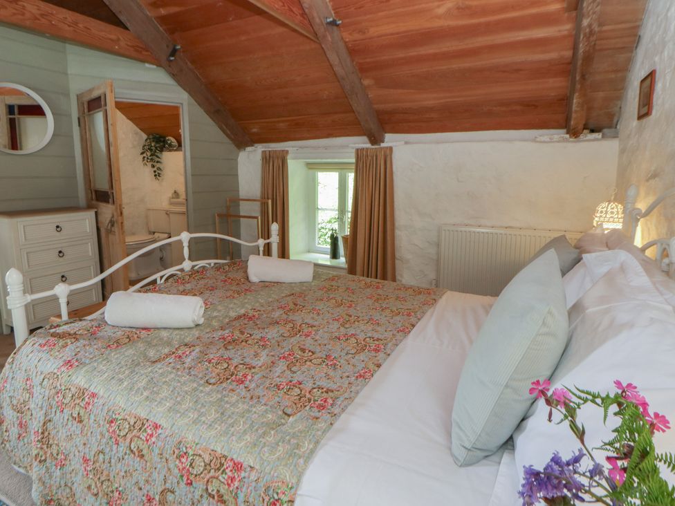 A bedroom with a bed and dresser at Sycamore Vestry in Pontfaen near Fishguard