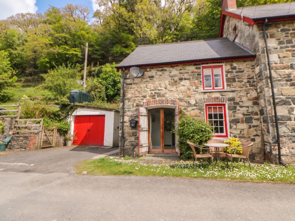 An outdoor area with a stone cottage and garden furniture at Sycamore Vestry in Pontfaen near Fishguard