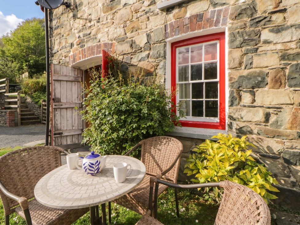 An outdoor seating area with table and chairs at Sycamore Vestry Pontfaen near Fishguard