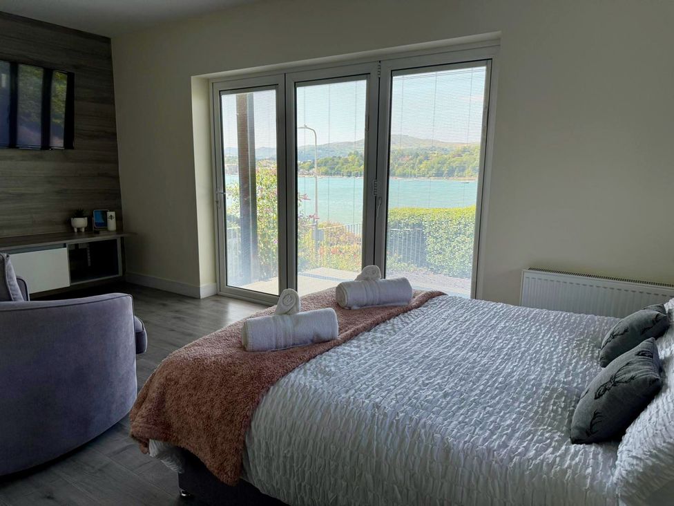 A bedroom with a bed and television at The Old Tywyn Post Office in Deganwy