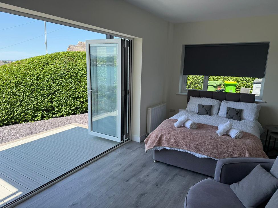 A bedroom with a bed and towels at The Old Tywyn Post Office in Deganwy