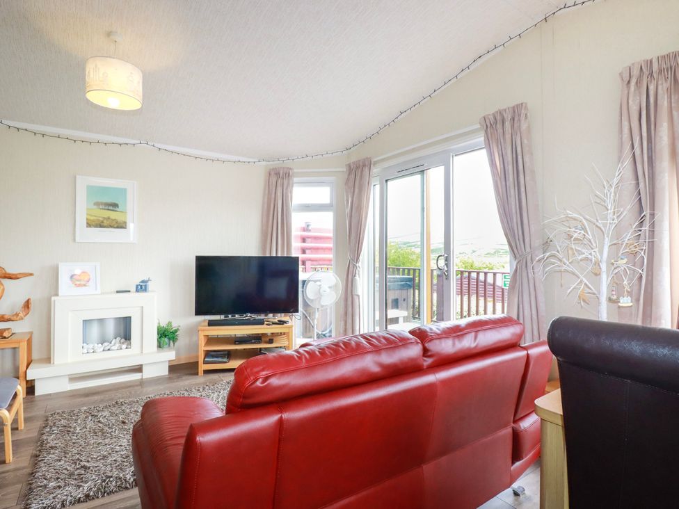A living room with a television and sofa at Chi Prenn Byhan in Tintagel