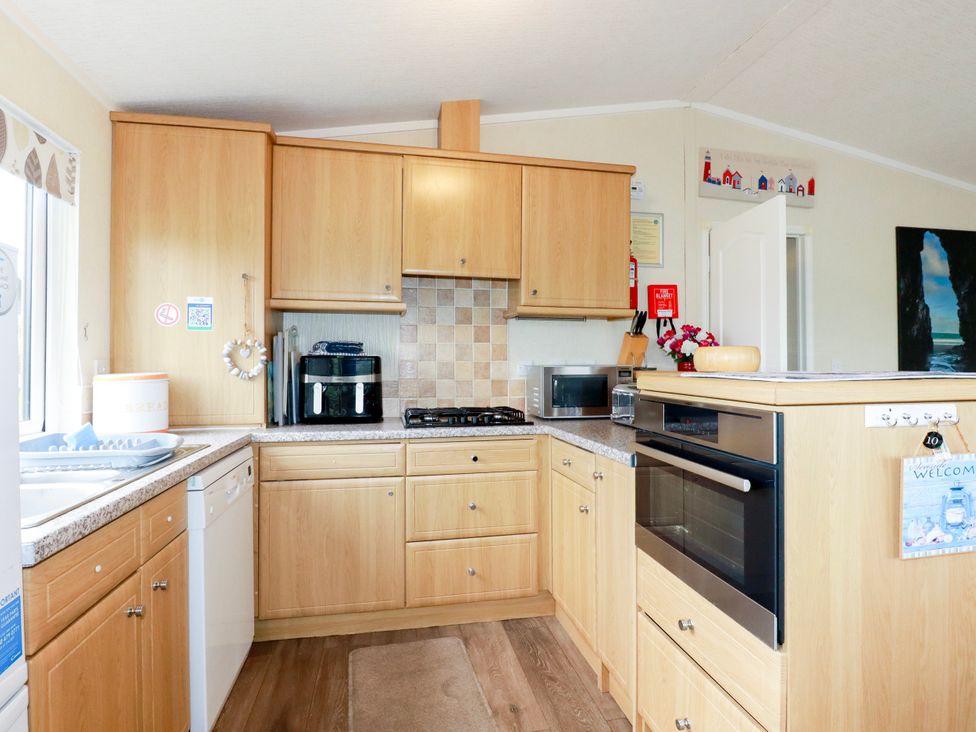 A kitchen with cabinets and appliances at Chi Prenn Byhan in Tintagel