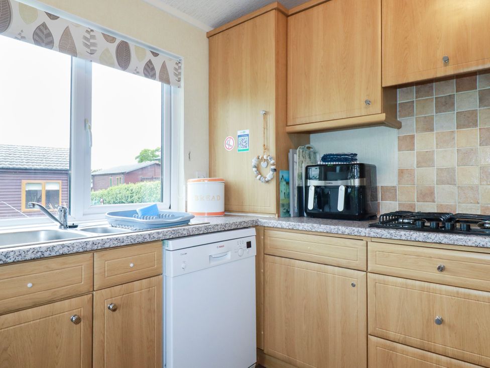 A kitchen featuring a sink, dishwasher, and coffee maker at Chi Prenn Byhan in Tintagel