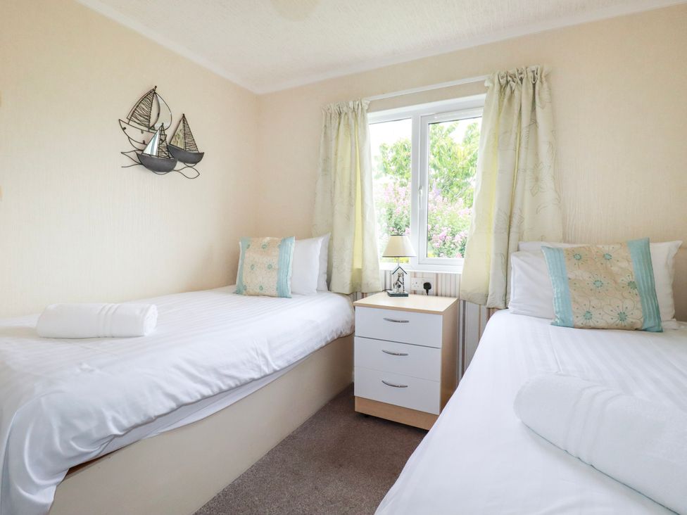 A bedroom with two beds and a bedside table at Chi Prenn Byhan in Tintagel