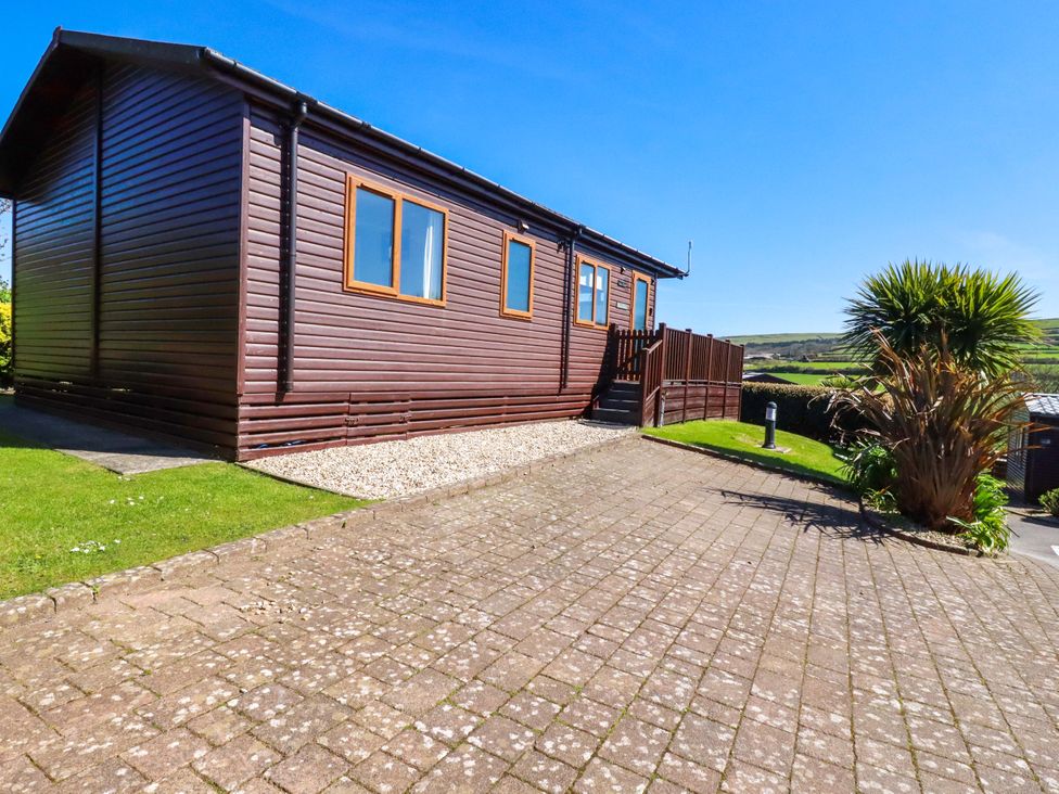 A wooden building with windows and steps at Chi Prenn Byhan in Tintagel