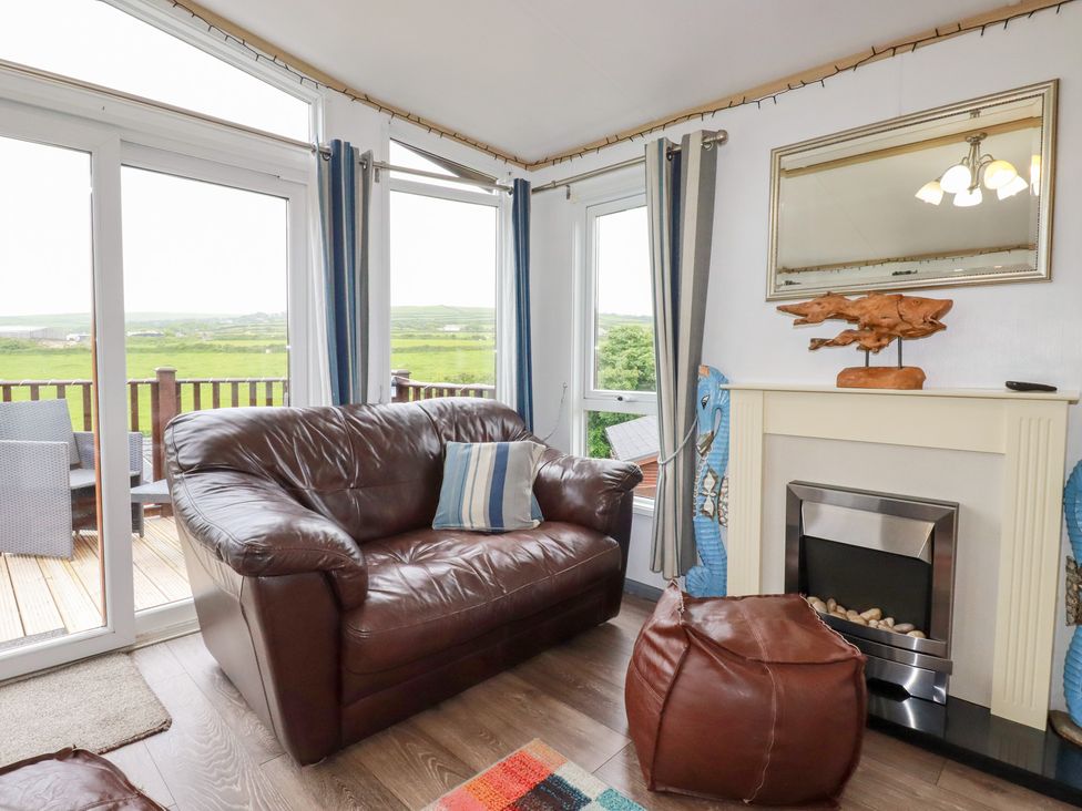 A living room with a sofa and fireplace at Orchard View in Bossiney near Tintagel