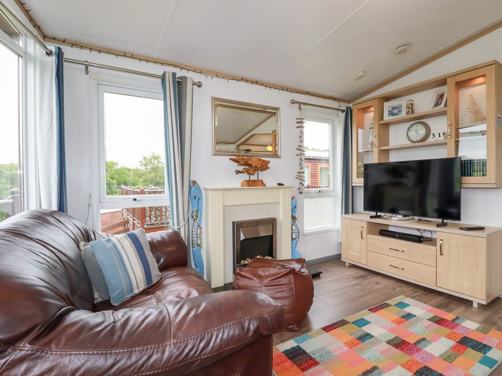 A living room with a sofa and television at Orchard View, Bossiney near Tintagel