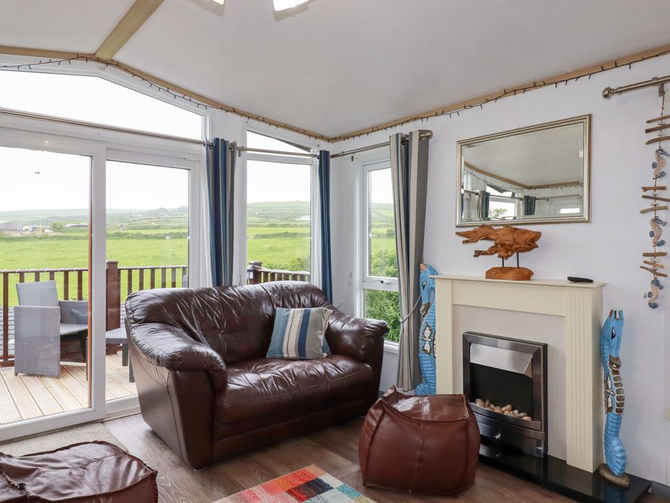 A living room with a sofa and fireplace at Orchard View in Bossiney near Tintagel