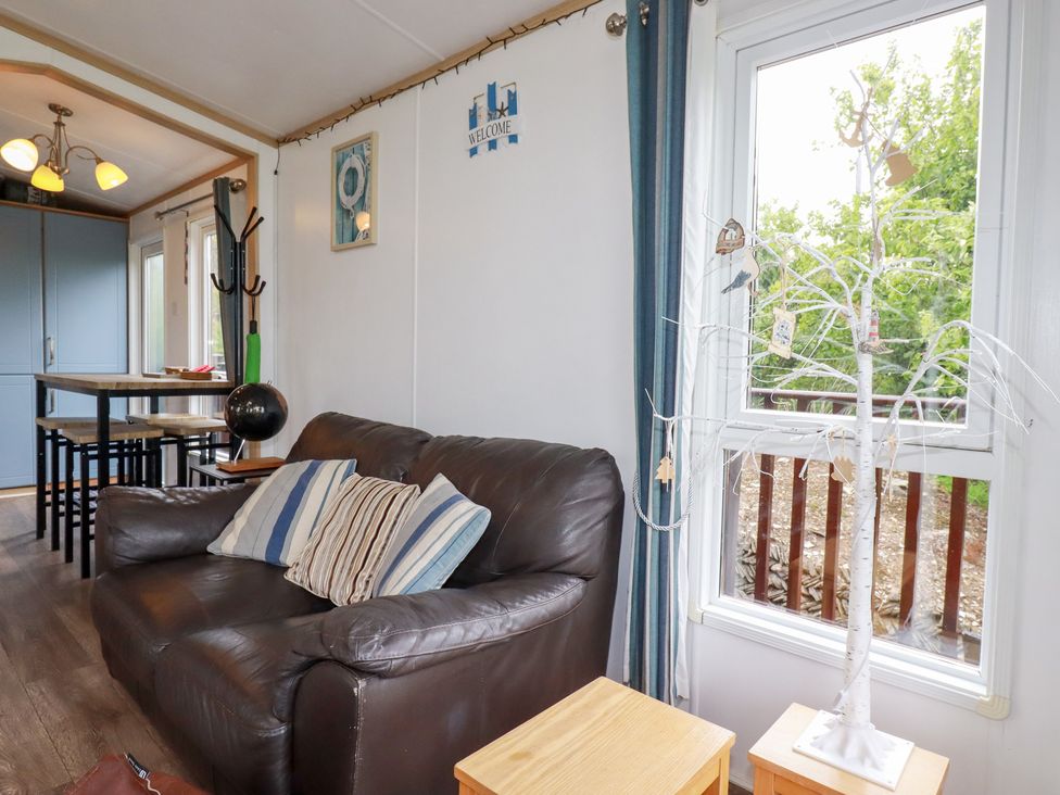 A living room with a sofa and dining table at Orchard View near Bossiney Tintagel