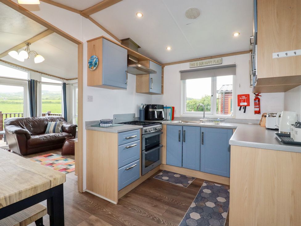 A kitchen with cabinets and appliances at Orchard View in Bossiney near Tintagel