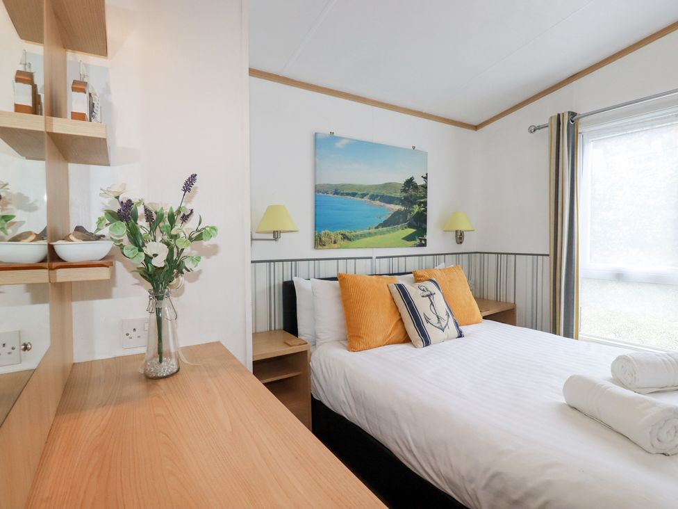 A bedroom with a bed and a picture at Orchard View Bossiney near Tintagel
