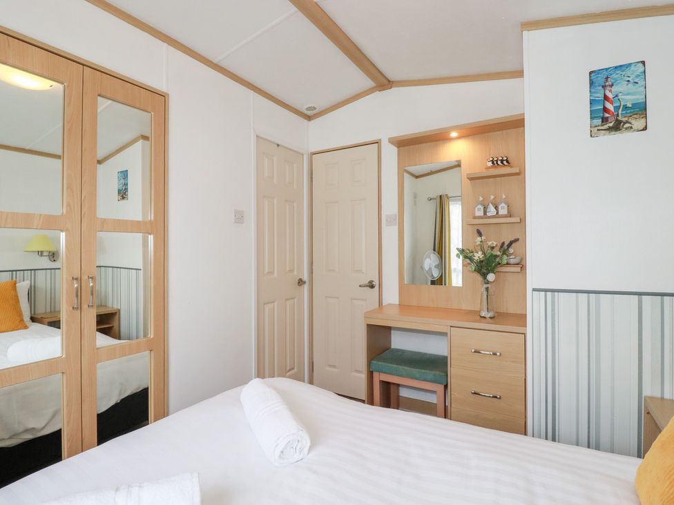 A bedroom with a bed and dresser at Orchard View near Bossiney Tintagel
