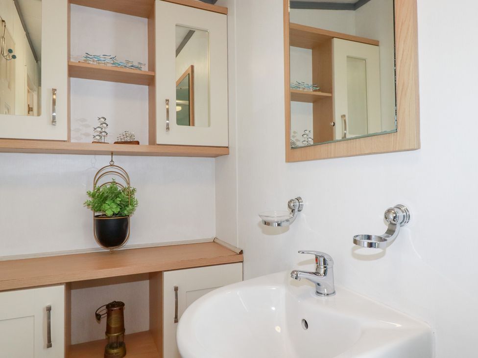 A bathroom with a sink and cabinet at Orchard View in Bossiney near Tintagel