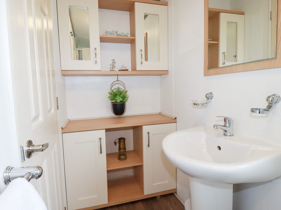A bathroom with a sink and cabinet at Orchard View in Bossiney near Tintagel