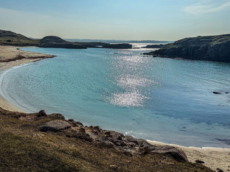 A beach with water and rocks at The Captain's Nest in Bunbeg, County Donegal