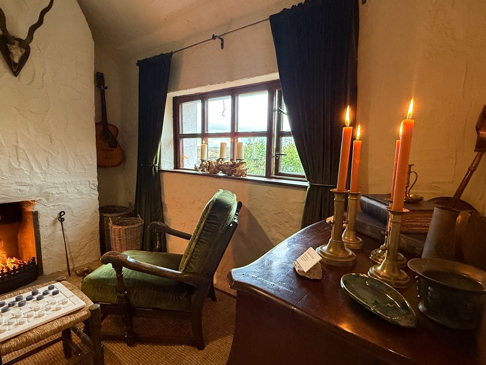 A snug with a fireplace and candles at The Captain's Nest in Bunbeg, County Donegal