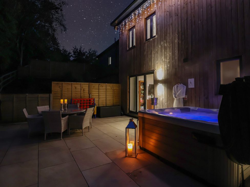 A garden with a hot tub and outdoor dining area at Stag Cottage in Lytchett Matravers