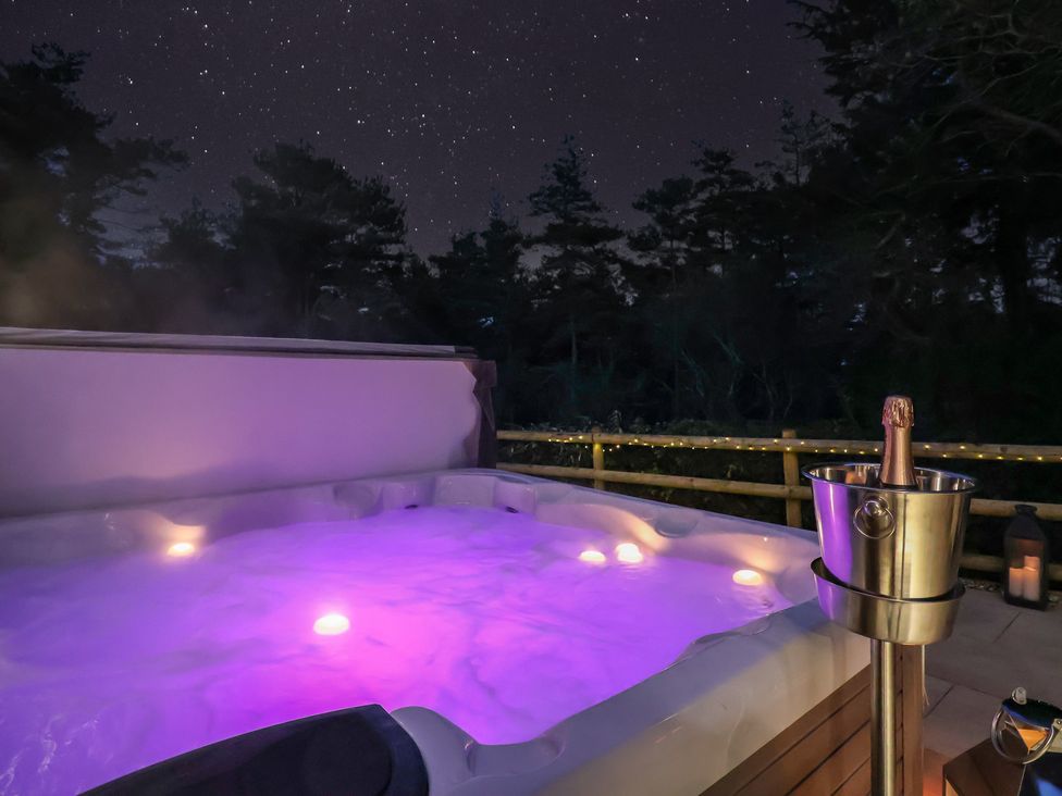 A hot tub with purple lights and a champagne bucket at Stag Cottage in Lytchett Matravers