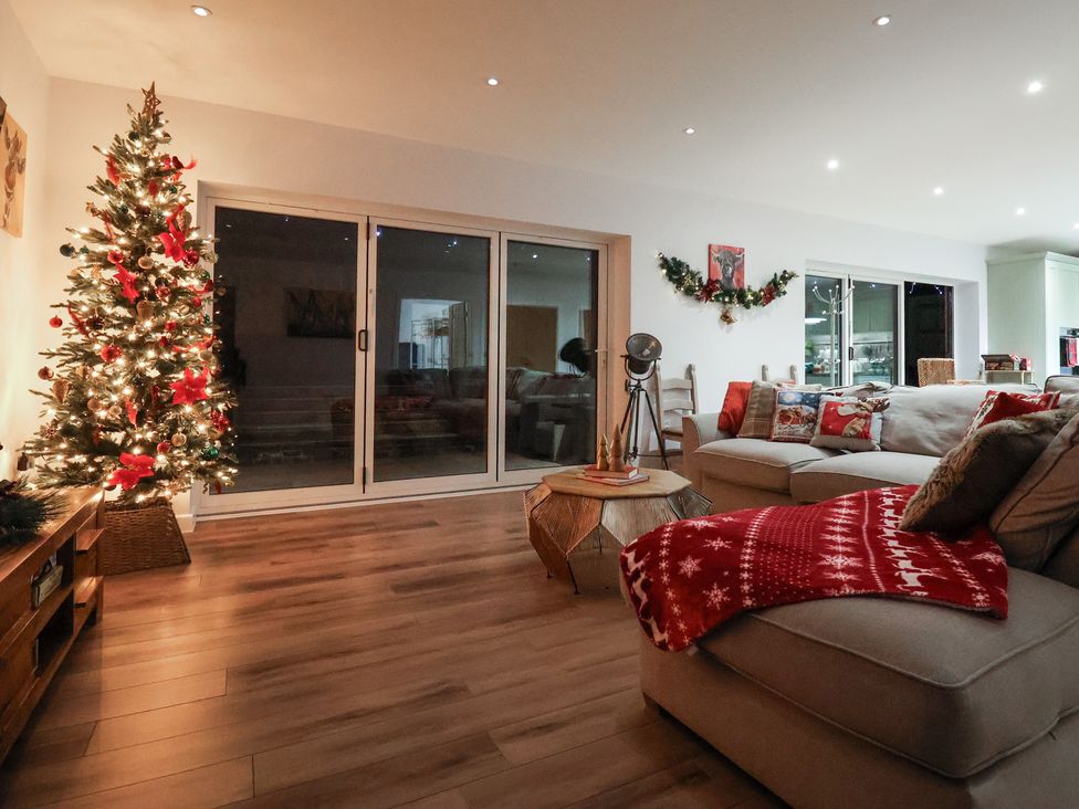 A living room with a Christmas tree and sofa at The Barn in Lytchett Matravers