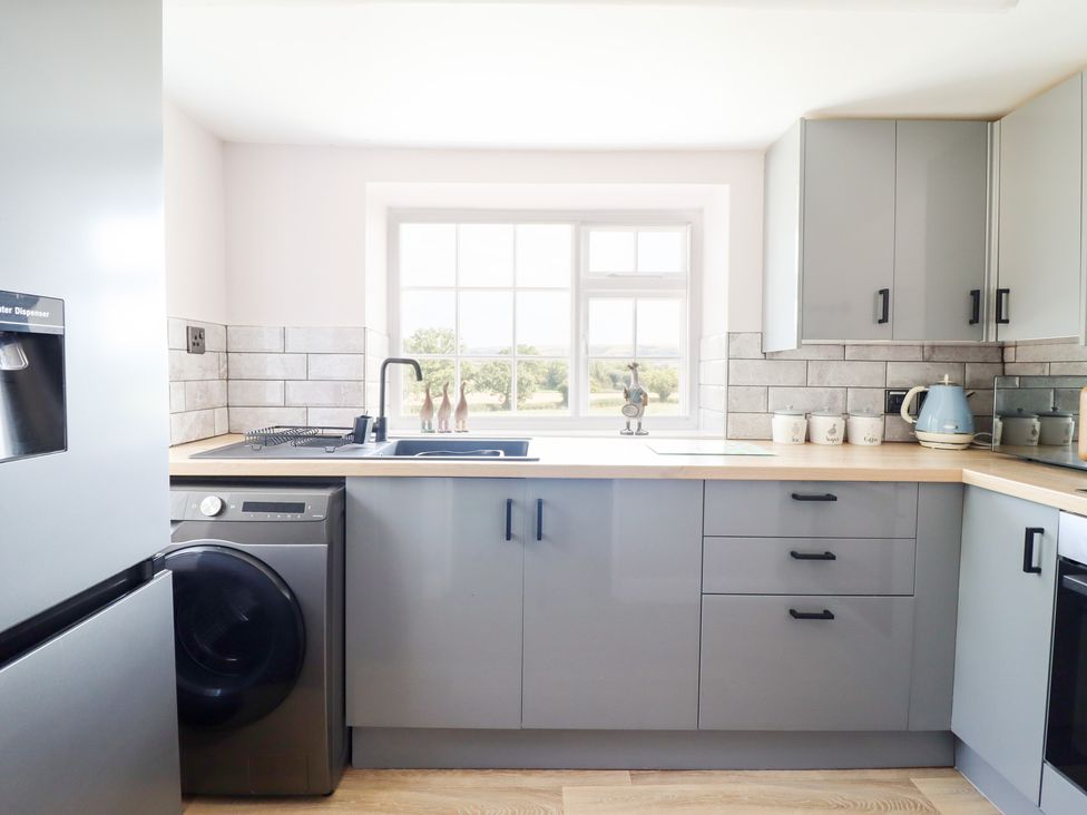 A kitchen with appliances and a window at Burgedin Locks Cottage Arddleen near Llandrinio