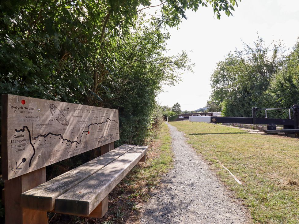 A pathway with a bench and an information sign near a canal lock at Burgedin Locks Cottage Arddleen near Llandrinio