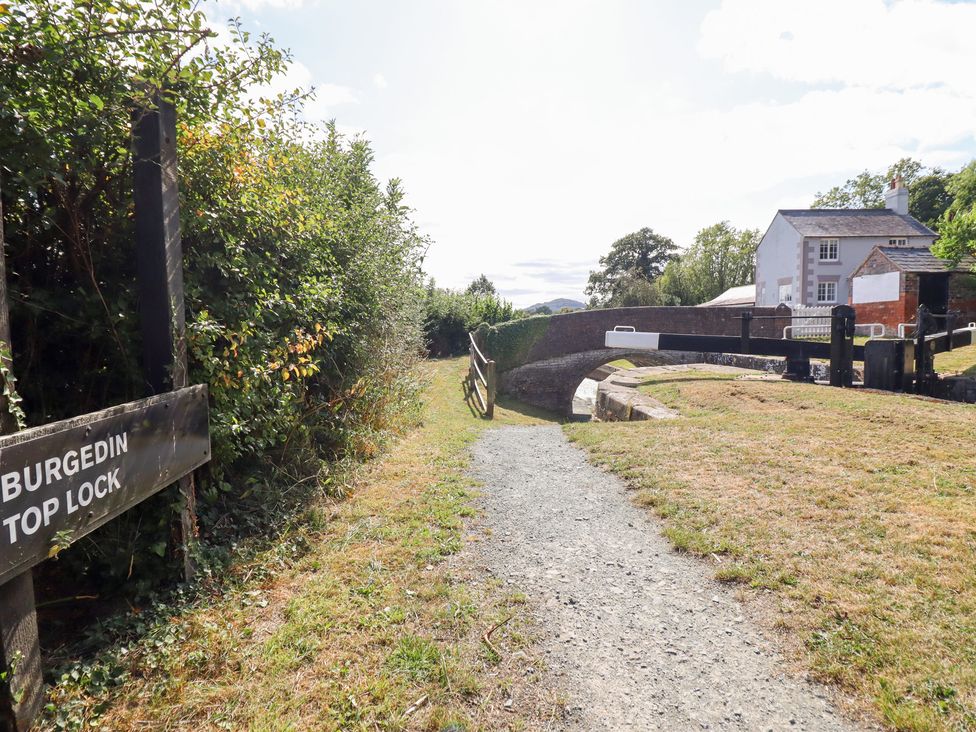 A pathway near Burgedin Top Lock with a bridge and surrounding greenery at Burgedin Locks Cottage Arddleen near Llandrinio