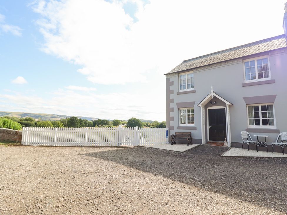 An outdoor view of a house with a gate and seating area at Burgedin Locks Cottage in Arddleen near Llandrinio