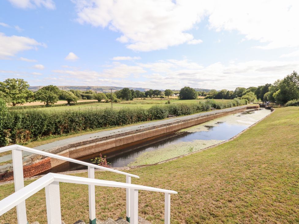 A canal with grass and trees beside it at Burgedin Locks Cottage Arddleen near Llandrinio