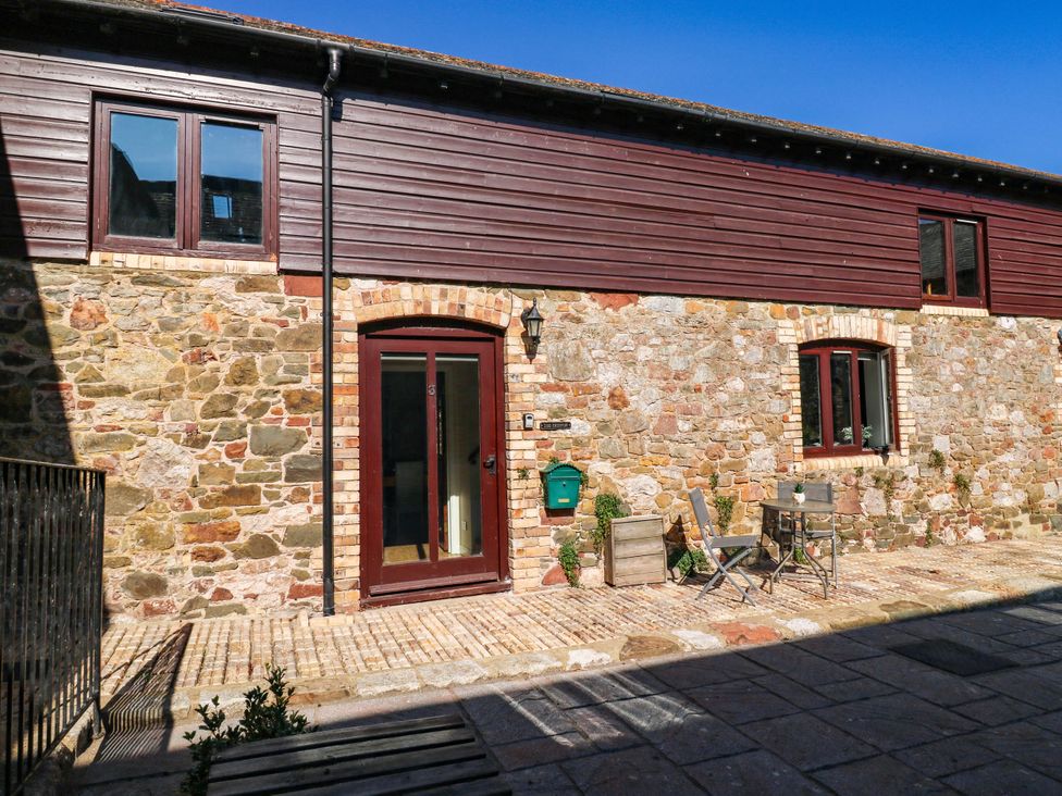 An outdoor area with stone wall and seating at 3 Town Farm Court Newton Abbot