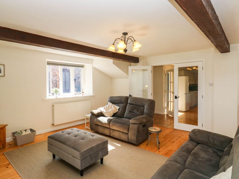 A living room with a couch, ottoman, and window at 3 Town Farm Court Newton Abbot