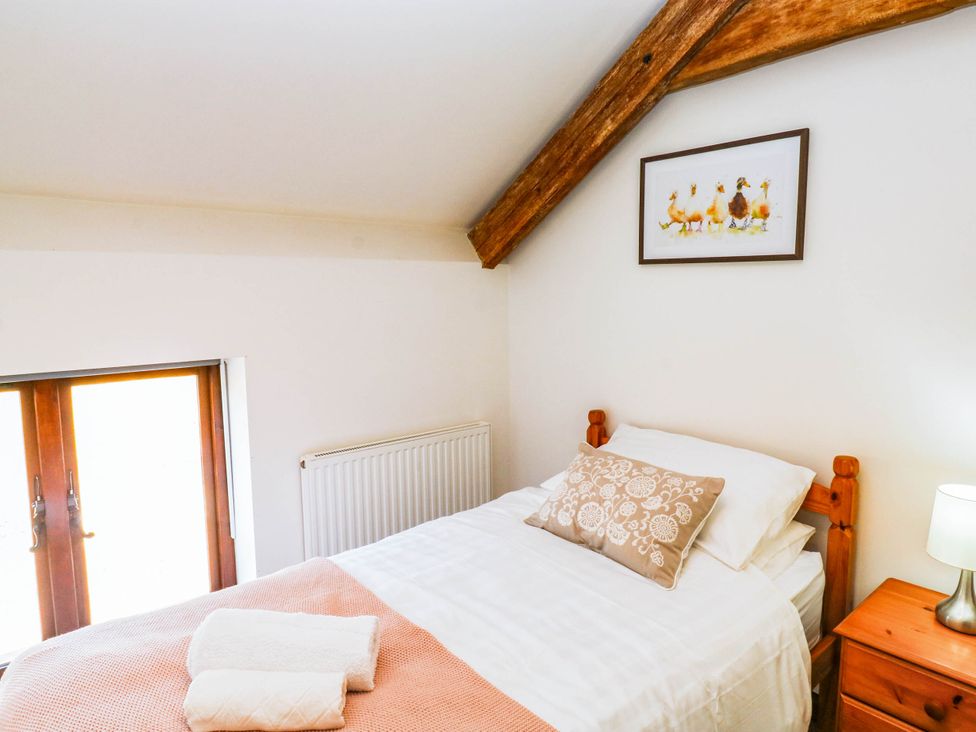 A bedroom with a bed and nightstand at 3 Town Farm Court, Newton Abbot