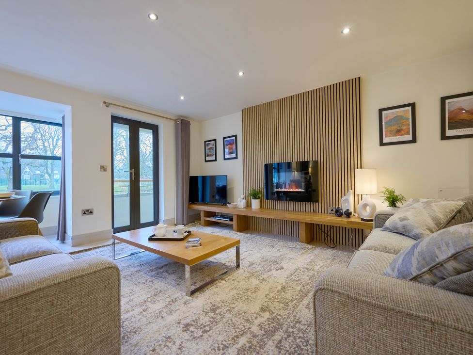 A living room with a sofa coffee table and television at Riverside Park 1 Keswick
