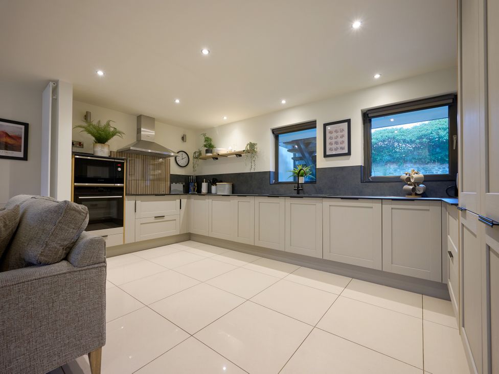 A kitchen with modern appliances and window view at Riverside Park 1 Keswick