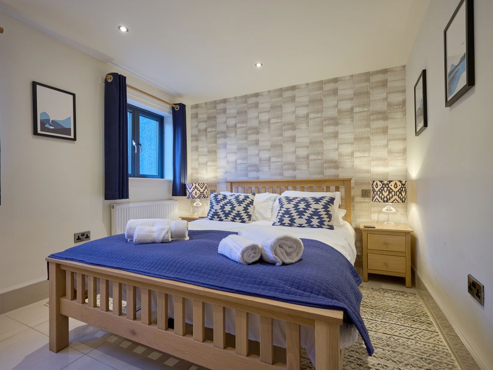 A bedroom with a bed and bedside table at Riverside Park 1 in Keswick