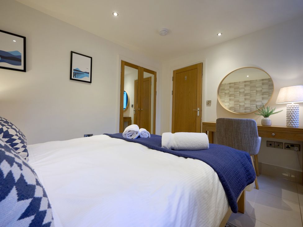 A bedroom with a bed, desk, and lamp at Riverside Park 1 in Keswick