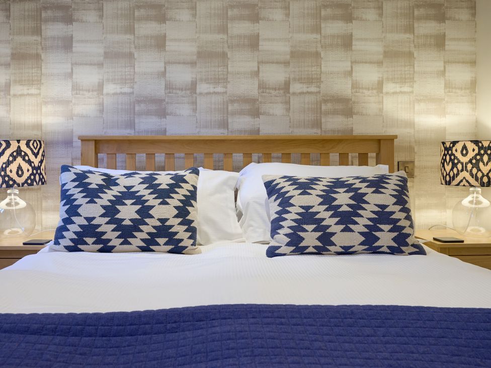 A bedroom with a bed and lamps at Riverside Park 1 in Keswick