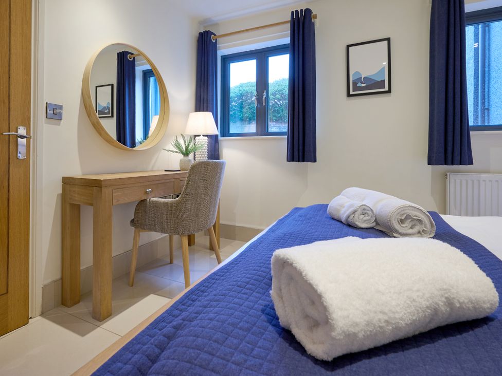 A bedroom with a bed and desk at Riverside Park 1 in Keswick