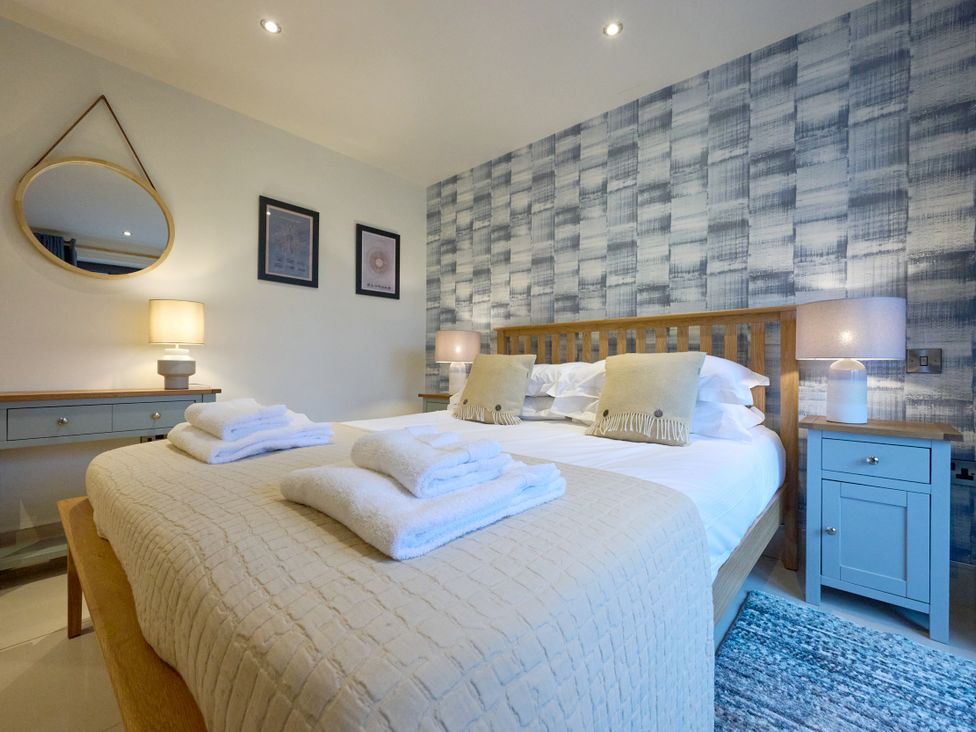 A bedroom with a bed, towels, and a lamp at Riverside Park 1 in Keswick