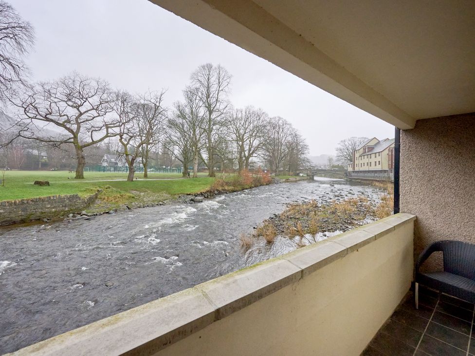 A view of a river and trees from a balcony at Riverside Park 1 in Keswick