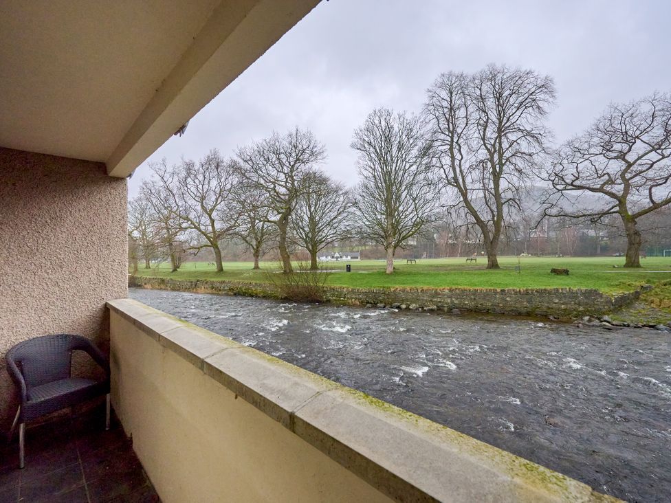 A balcony overlooking a river and trees at Riverside Park 1 Keswick