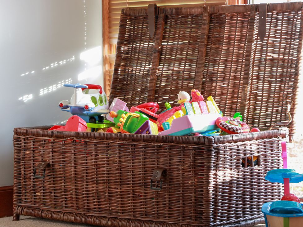 A toy box filled with colorful plastic toys in a playroom at Shieldhill Farm House Falkirk