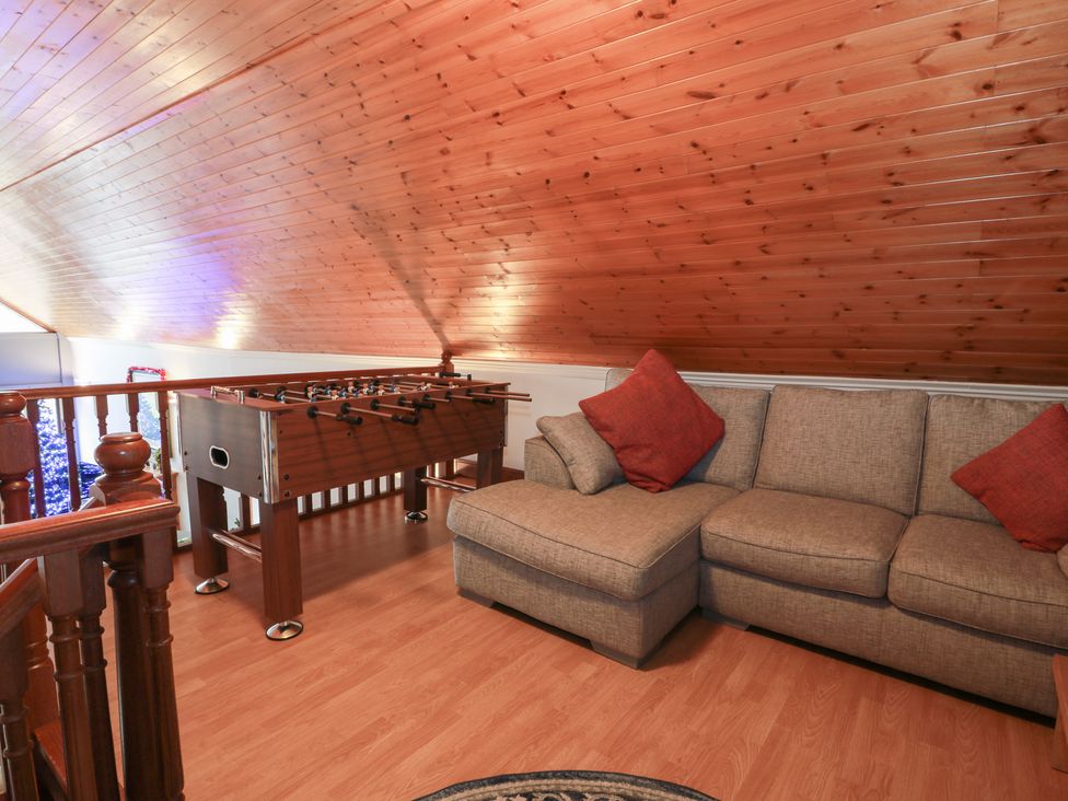 A loft with a sofa and foosball table at Shieldhill Farm House in Falkirk
