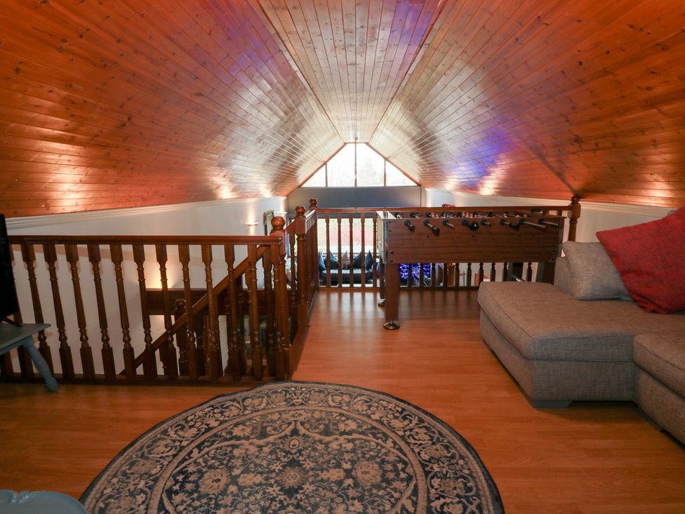 A loft with a sofa and foosball table at Shieldhill Farm House in Falkirk