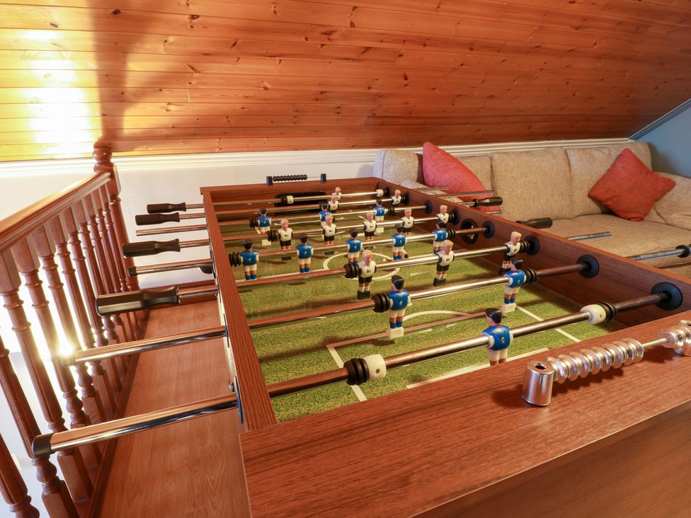 A game room with a foosball table and couch at Shieldhill Farm House in Falkirk