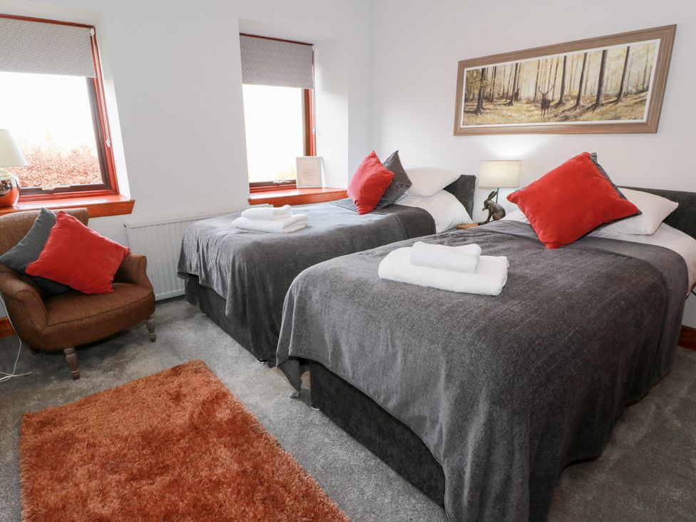A bedroom with two beds and a chair at Shieldhill Farm House in Falkirk