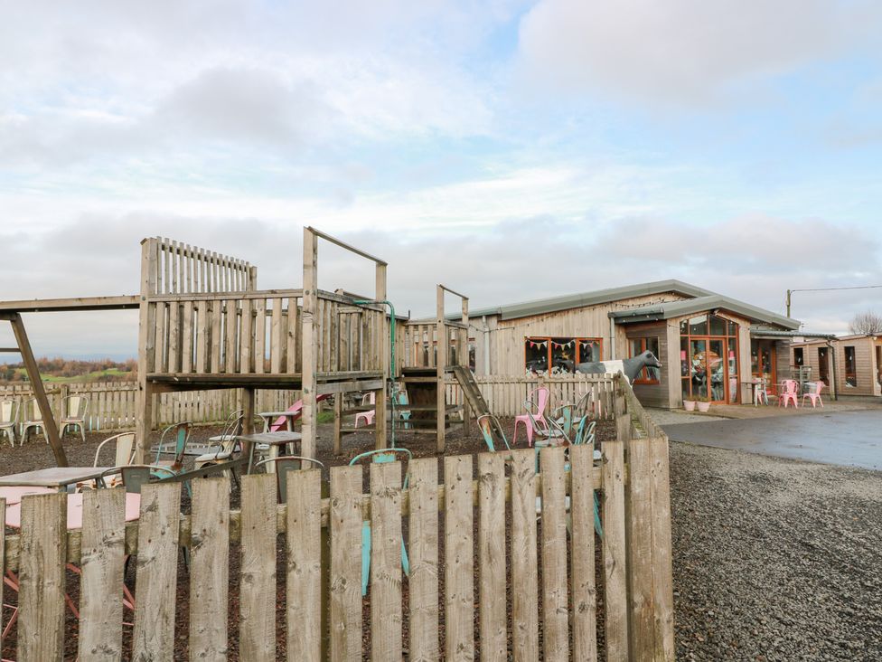 An outdoor play area with a wooden structure and seating at Shieldhill Farm House in Falkirk