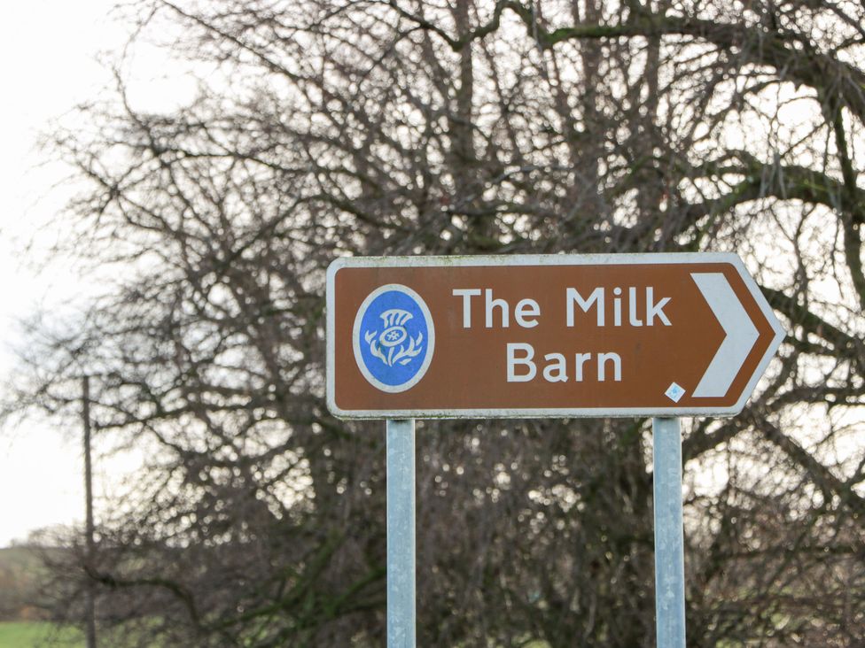 A directional sign for The Milk Barn